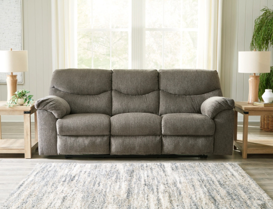 gray soft-backed couch in front of a window flanked by two side tables with lamps